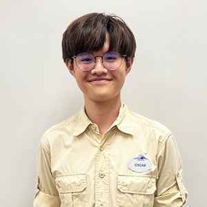 Disney intern Oscar with short brown hair and a yellow shirt smiling