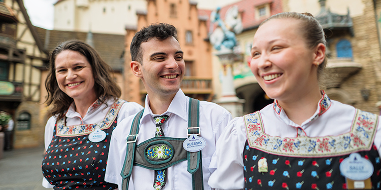Cast members laughing and smiling while in EPCOT's Germany Pavilion at Walt Disney World.