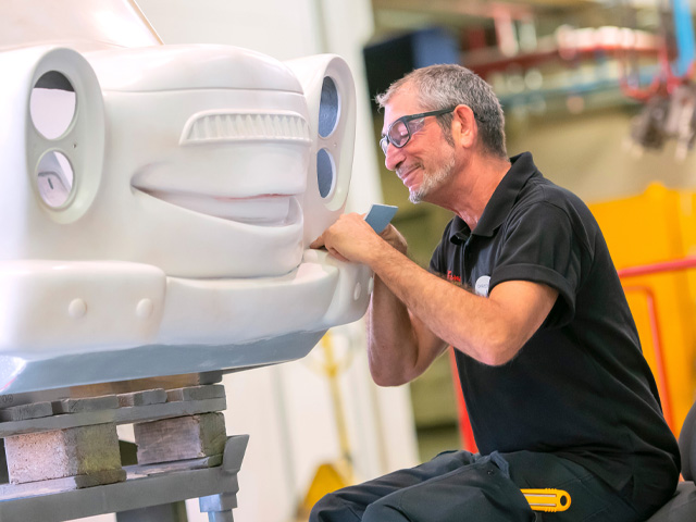 Technology engineering professional inspecting and refining a large attraction vehicle prototype in a workshop