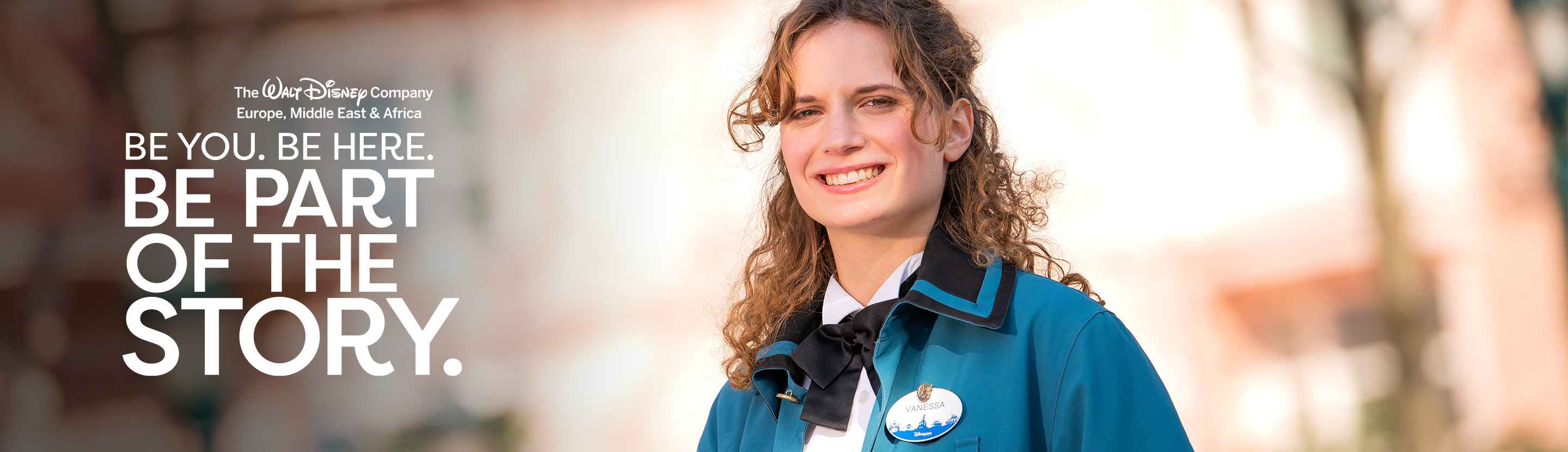 A smiling Operations employee in a teal jacket
