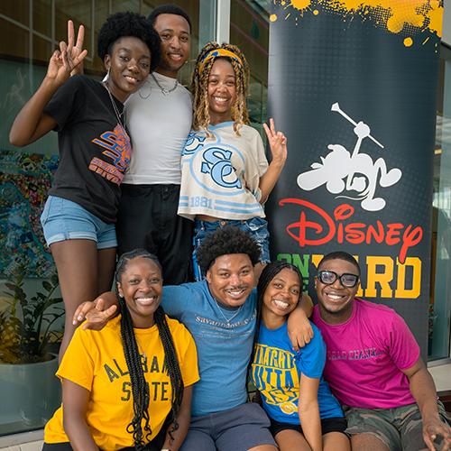 group of young black college students smiling at Disney on the Yard event