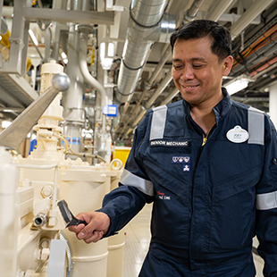 male crew member in uniform, performing maintenance on the lower decks