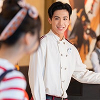 Hong Kong Disneyland Resort hotel Male Bell Services employee smiling at a guest