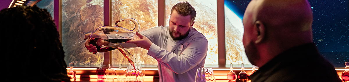 bartender pouring drinks for guests at a futuristic hotel bar