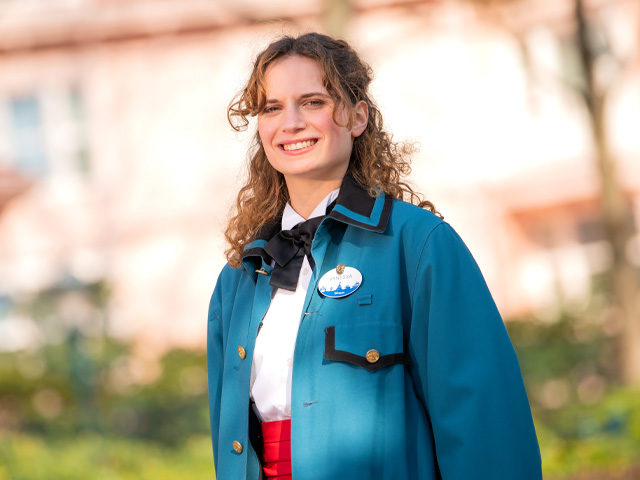 A smiling Operations employee in a teal jacket