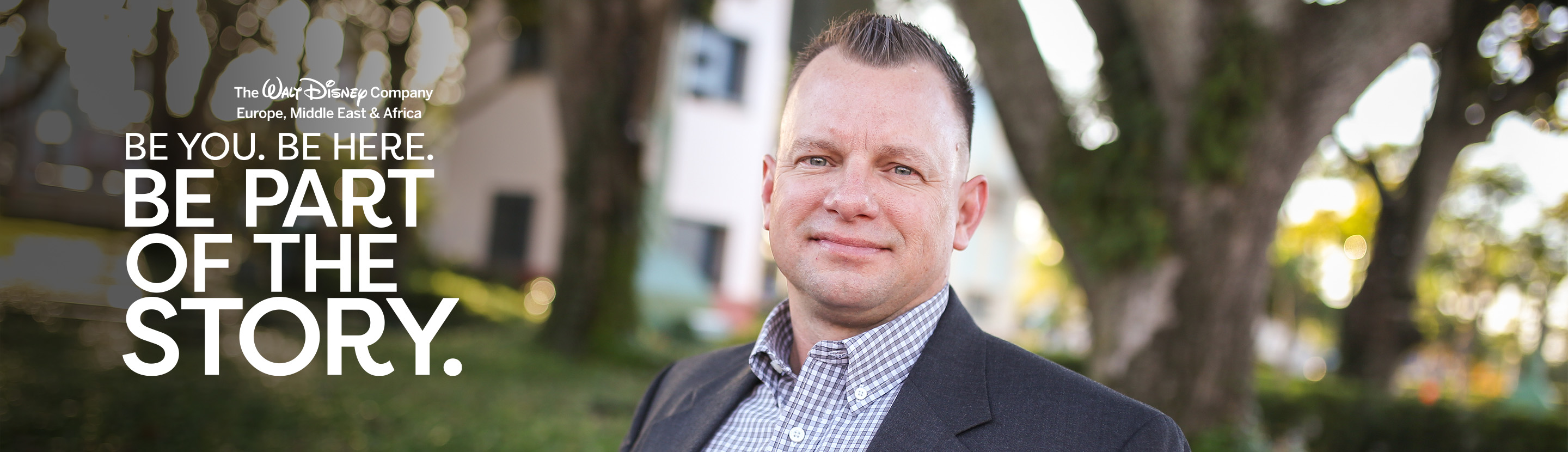 Sales and business development professional posing in an outdoor workplace setting
