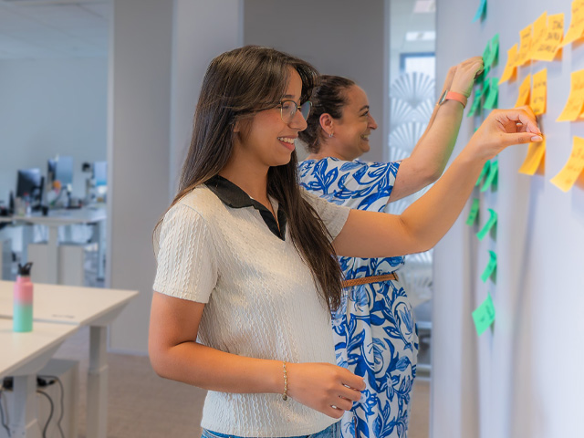 Two women brainstorming Data Analytics ideas with sticky notes