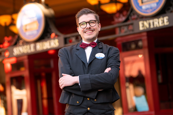 Smiling professional in a suit standing in front of an attraction entrance