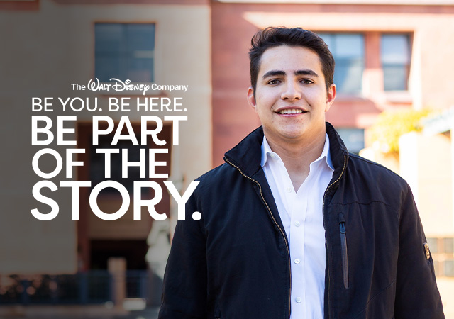 Smiling man with the iconic Disney "Partners" statue