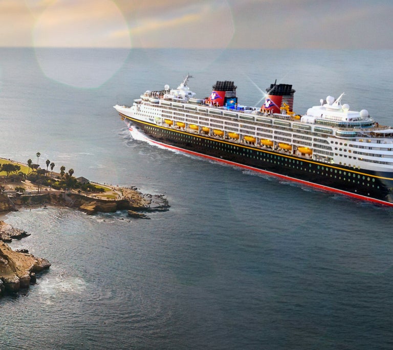 Disney Cruise Line ship sailing alongside the coast of an island