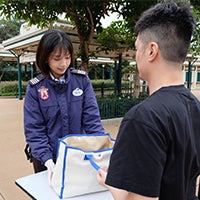 Female security guard checking a bag at Hong Kong Disneyland Resort