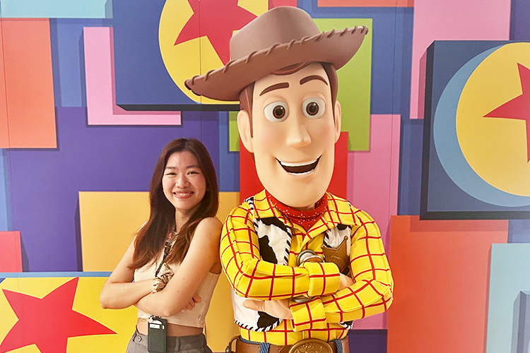 The Walt Disney Company APAC intern Rosy smiling and standing shoulder to shoulder with Toy Story's Woody