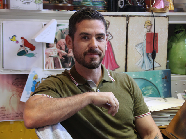Creative professional working in a design studio featuring Disney character sketches and artwork displays