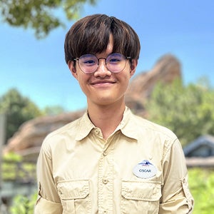 Disney intern Oscar with short brown hair and a yellow shirt smiling