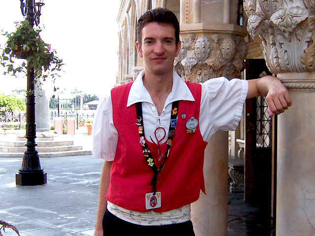 Smiling man in a red vest at EPCOT