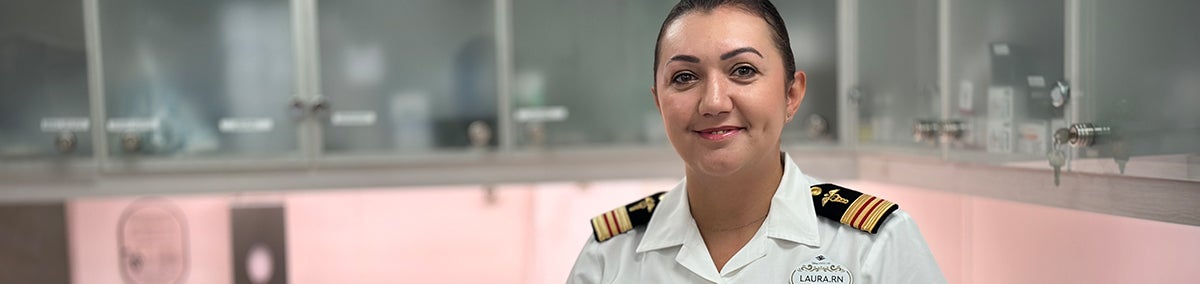 Female medical staff member in uniform and smiling in a medical exam room