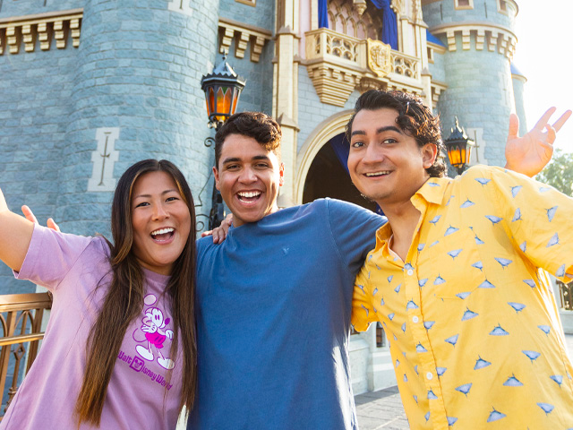 Joyful friends pose in front of Cinderella Castle