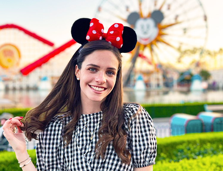 The Walt Disney Company Latin America female Intern wearing a checkered top and Minnie Mouse ears smiling