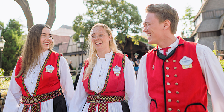 Cast members smiling and laughing together while in EPCOT's Norway Pavilion at Walt Disney World.