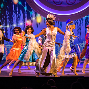 female dancers on stage, performing in 'roaring twenties' costumes