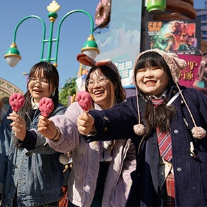 a young Asian woman receiving a hug from two Disney cast members in Duffy and ShellieMay teddy bear costumes