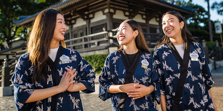 Cast members laughing and smiling while standing in EPCOT's Japan Pavilion at Walt Disney.