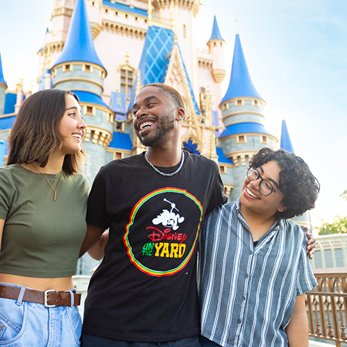 Three people smiling in front of Cinderella's castle at Magic Kingdom