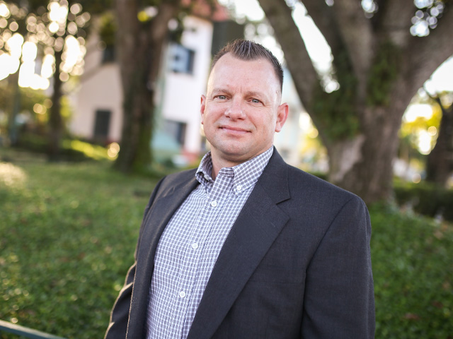 Sales and business development professional posing in an outdoor workplace setting
