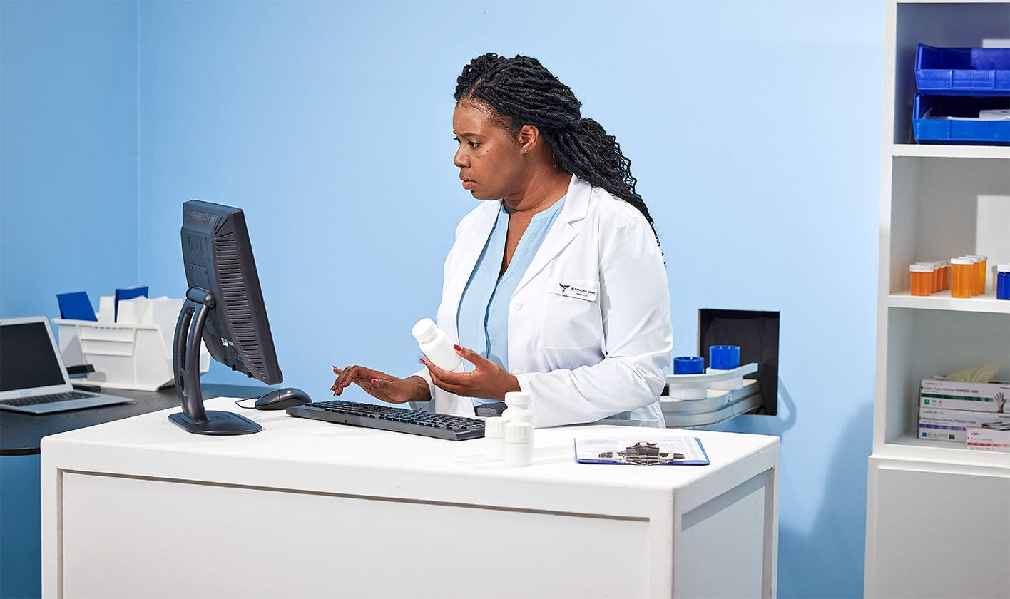 Pharmacist interacting with computer