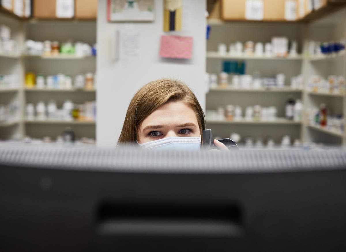 Pharmacist on the phone while reviewing computer screen