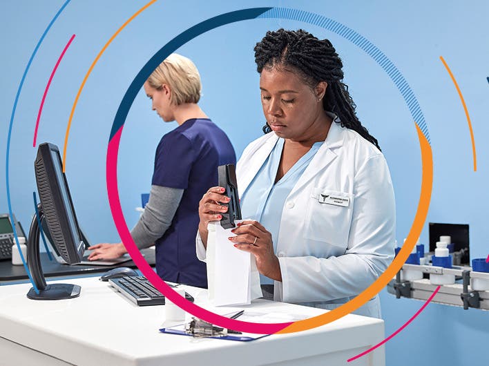 Pharmacist standing behind a counter stapling a prescription bag for a customer 