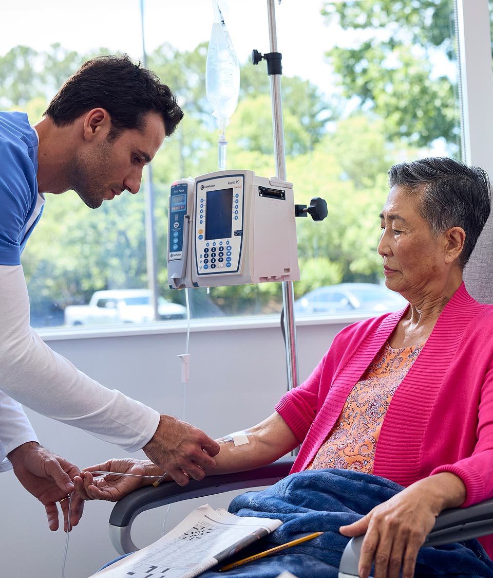 A provider puts an IV in a patient's arm