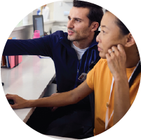 Two providers consulting with each other about something on a computer screen