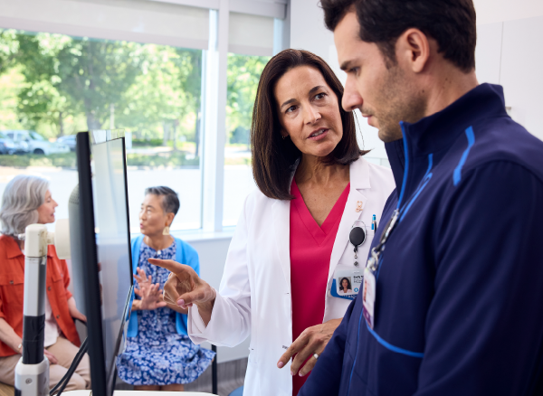 An image of a doctor consulting a health care professional at a computer