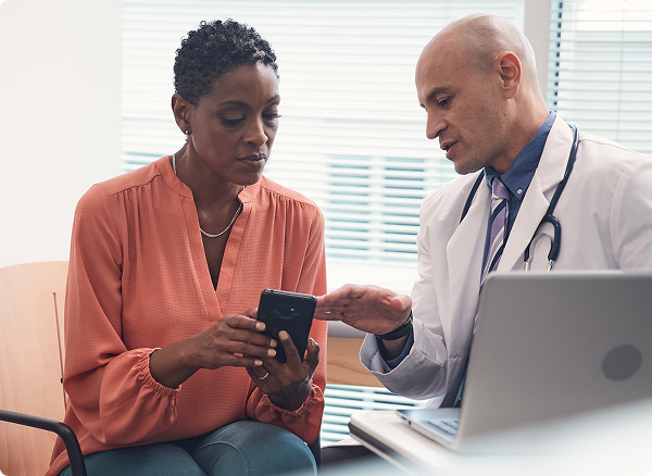 A photo of a doctor and a patient looking at a smartphone