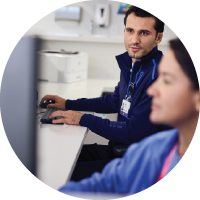 Two providers sitting at a computer in a medical office.