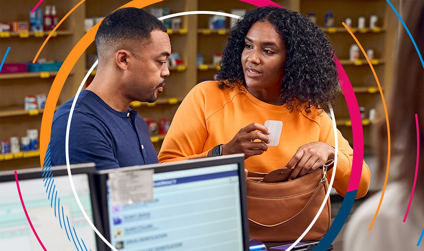 A patient and his spouse use a discount card at the pharmacy to help pay for a prescription.