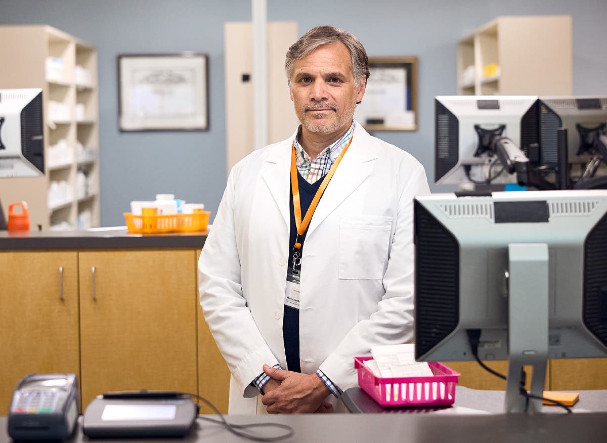 Portrait of pharmacist behind desk