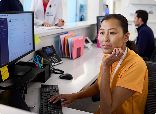 A member of a care team sitting at a computer analyzing a chart