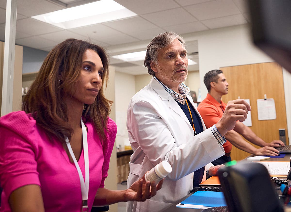 Pharmacists interact with computer