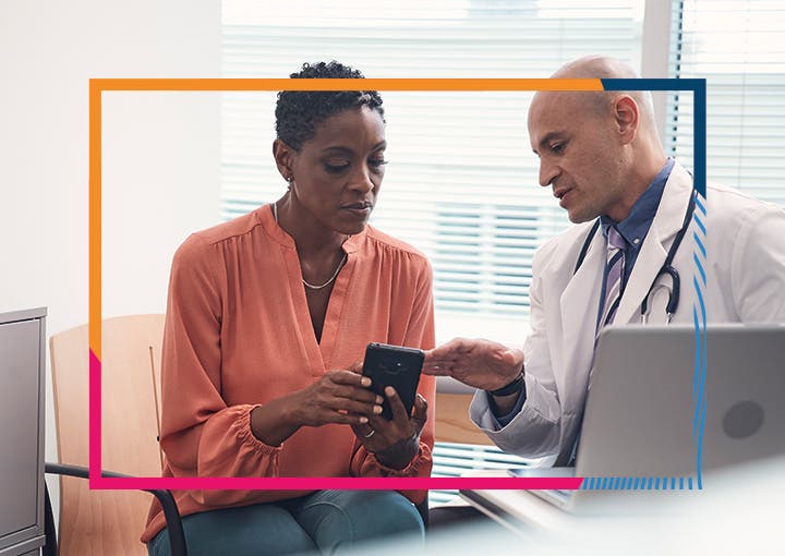 Image of a doctor showing a patient how to use an app on a smart phone