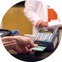 A patient inserting a chip card into a reader to pay for a medication.