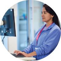 Medical professional typing at a mobile computer station