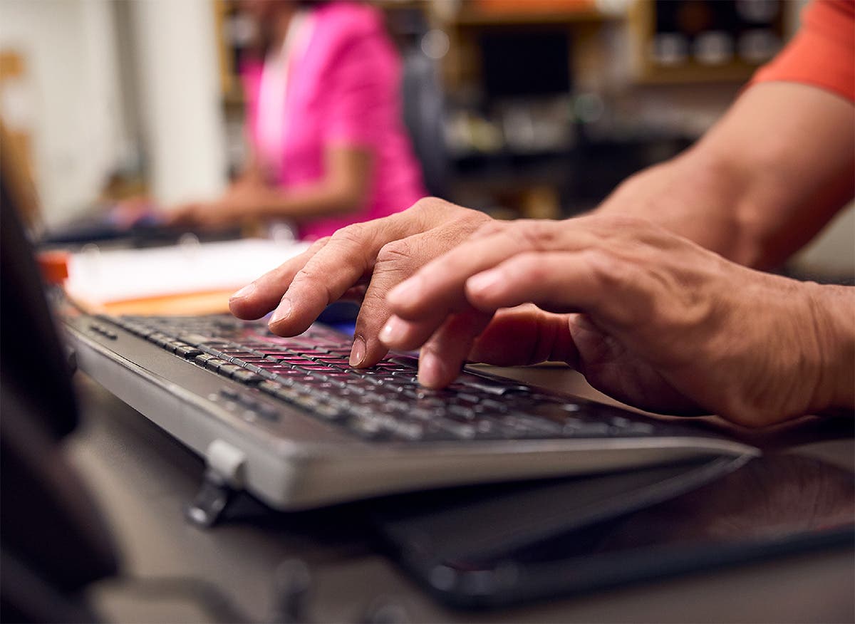 A pharmacist's hands typing on a keyboard