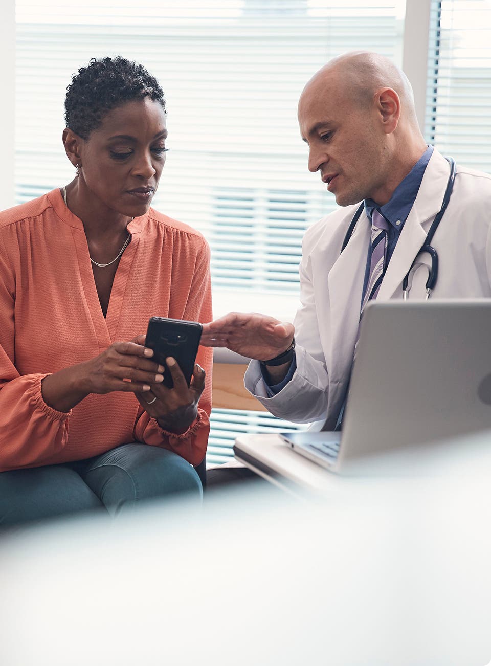 Patient and provider looking at phone in exam room