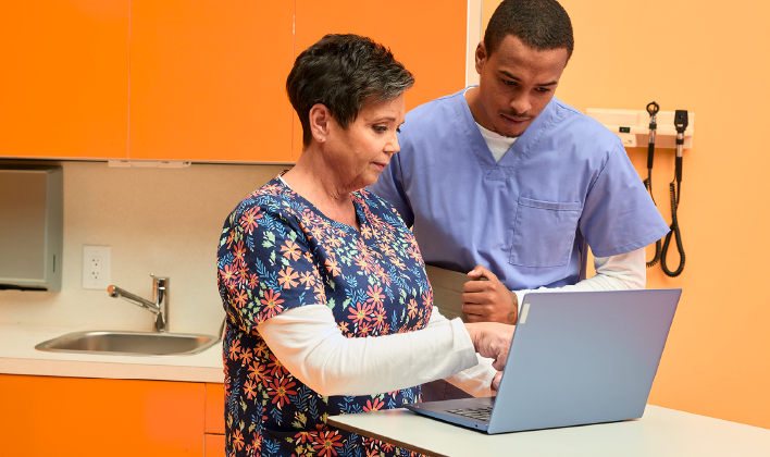 Providers consulting on a computer about a process in their prior authorization workflow.