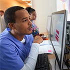 Care team members review an electronic prior authorization on a computer screen in a clinical setting