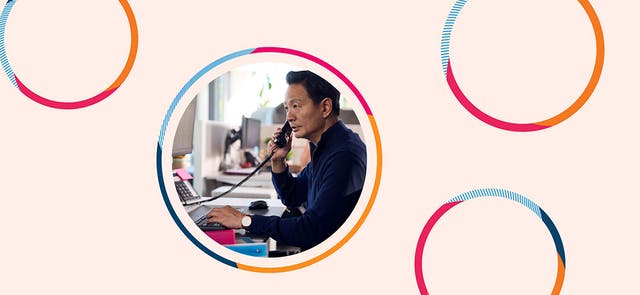 Image of a man sitting on the phone at a desk