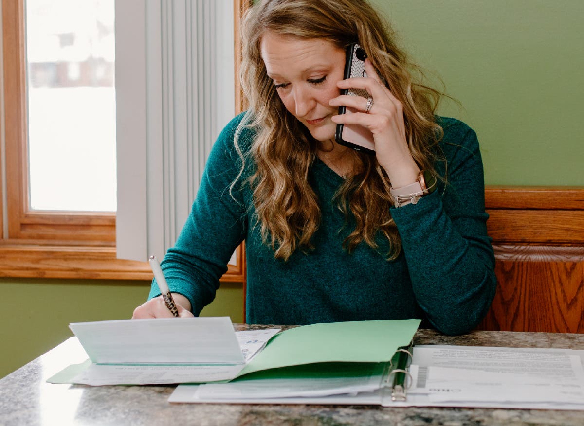 Patient on the phone reviewing healthcare paperwork