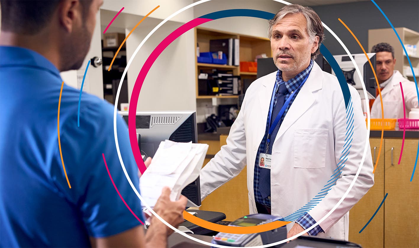 A pharmacist counsels patient and caregiver regarding their medication at the pharmacy counter.